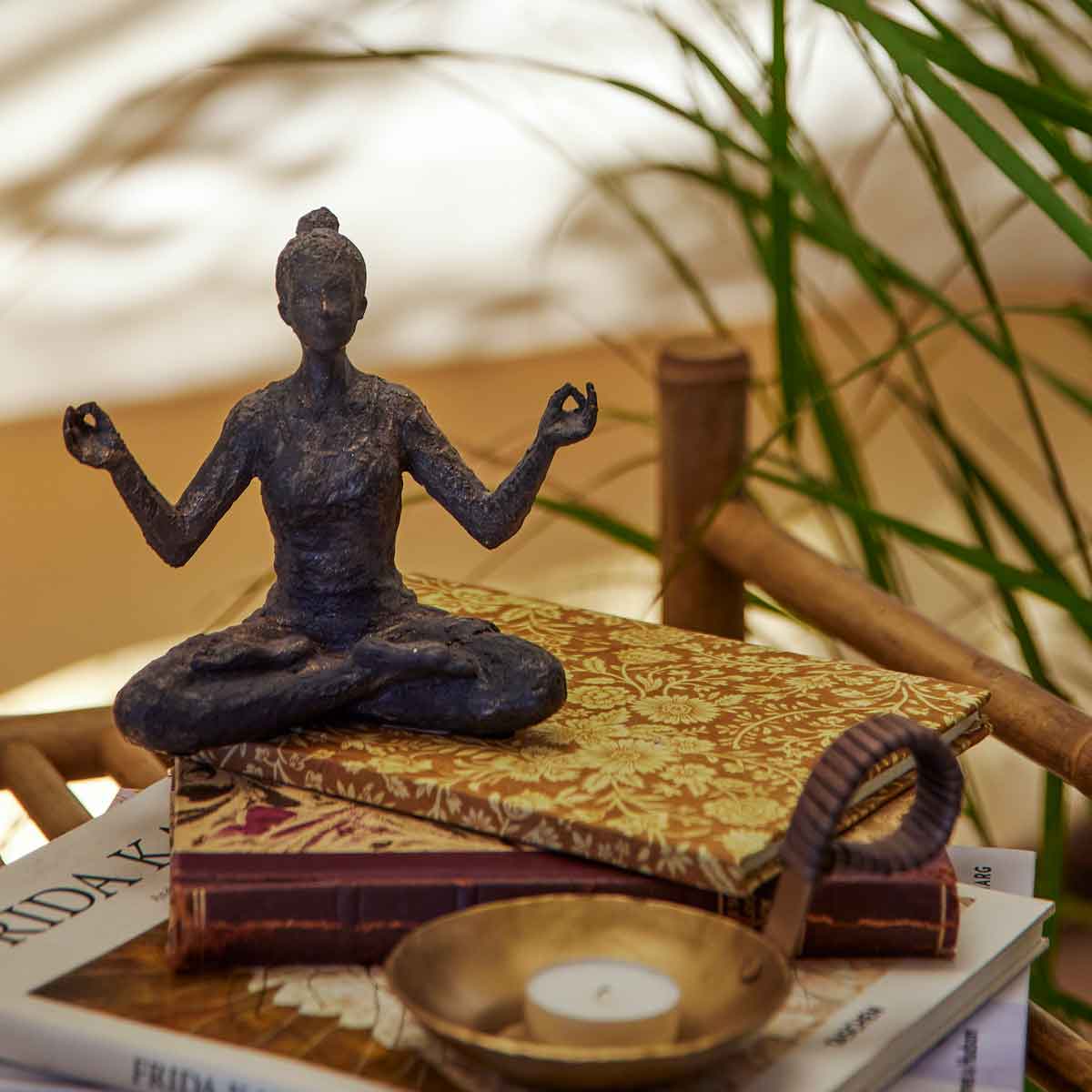 Miiral_82057513_2 Sitzende Yoga Frau mit geöffnetten Armen - in dekorativer Umgebung auf einem Tisch