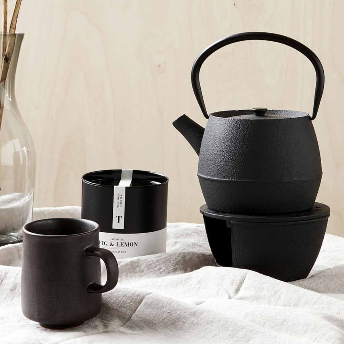 Schwarze Teekanne mit Henkel und Teesieb - auf Stövchen aus Eisen