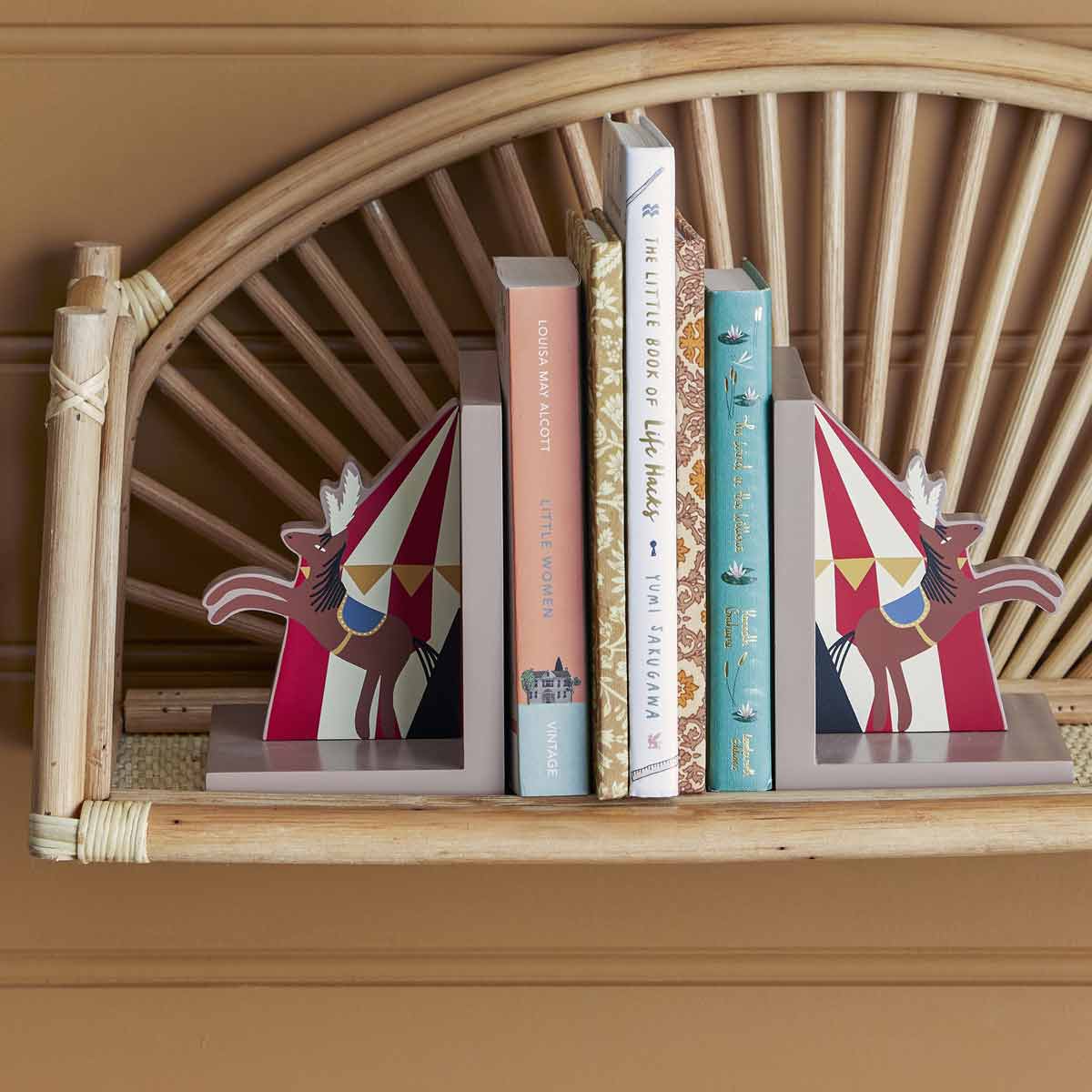 Buchstuetzen_Santos_82054319_3 Buchstützen aus Holz mit Zirkus Motiven - Nahansicht im Regal